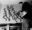 Portrait of Roy Kiyooka painting a mural in Heritage Hall, 1949